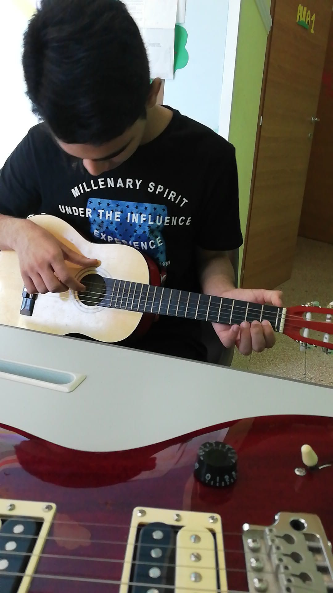 Ragazzo impara a suonare la chitarra